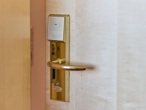 Goldener türgriff mit elektronischem kartenleser an einer hotellzimmer tür