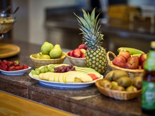 Verschiedene frische Früchte auf einem Tisch in Schalen und auf Tellern angerichtet